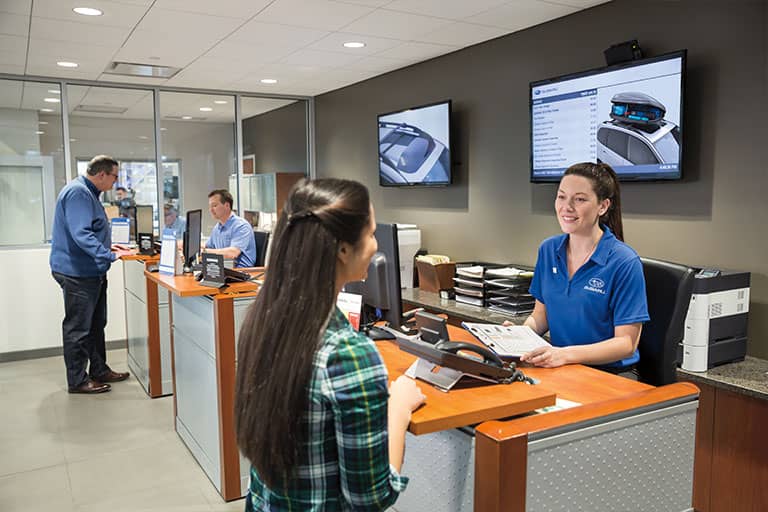 Service Advisor and female customer talking at a Subaru Service Desk