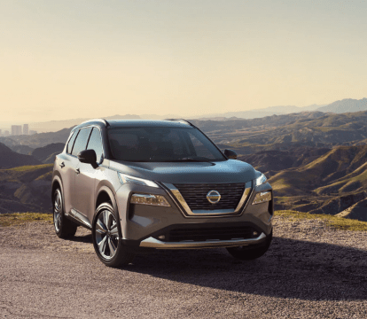 Front view of a silver 2022 Nissan Rogue parked in front of mountains