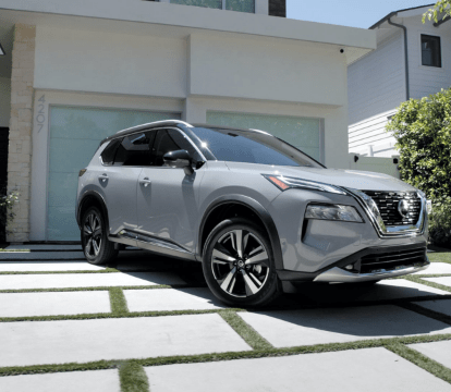 Front and side view of a silver 2022 Nissan Rogue parked on a stone driveway