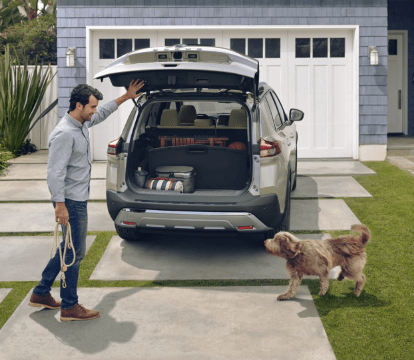 Man opening the trunk of his 2022 Nissan Rogue for his dog 
